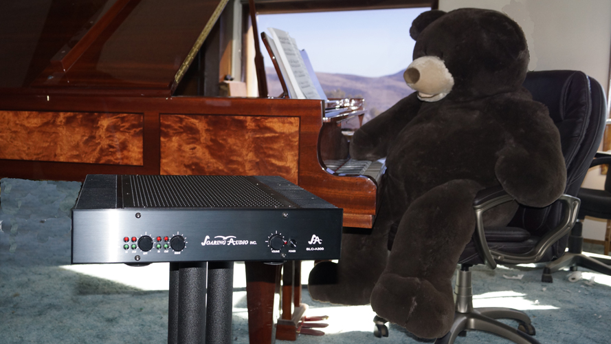 Soaring Audio Home Theater amplifier on stand by piano with stuffed bear